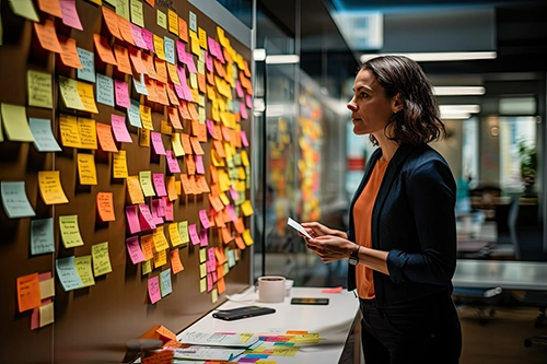 A woman looking at sticky notes on a wall in an office shows the challenges of creating an innovation strategy.